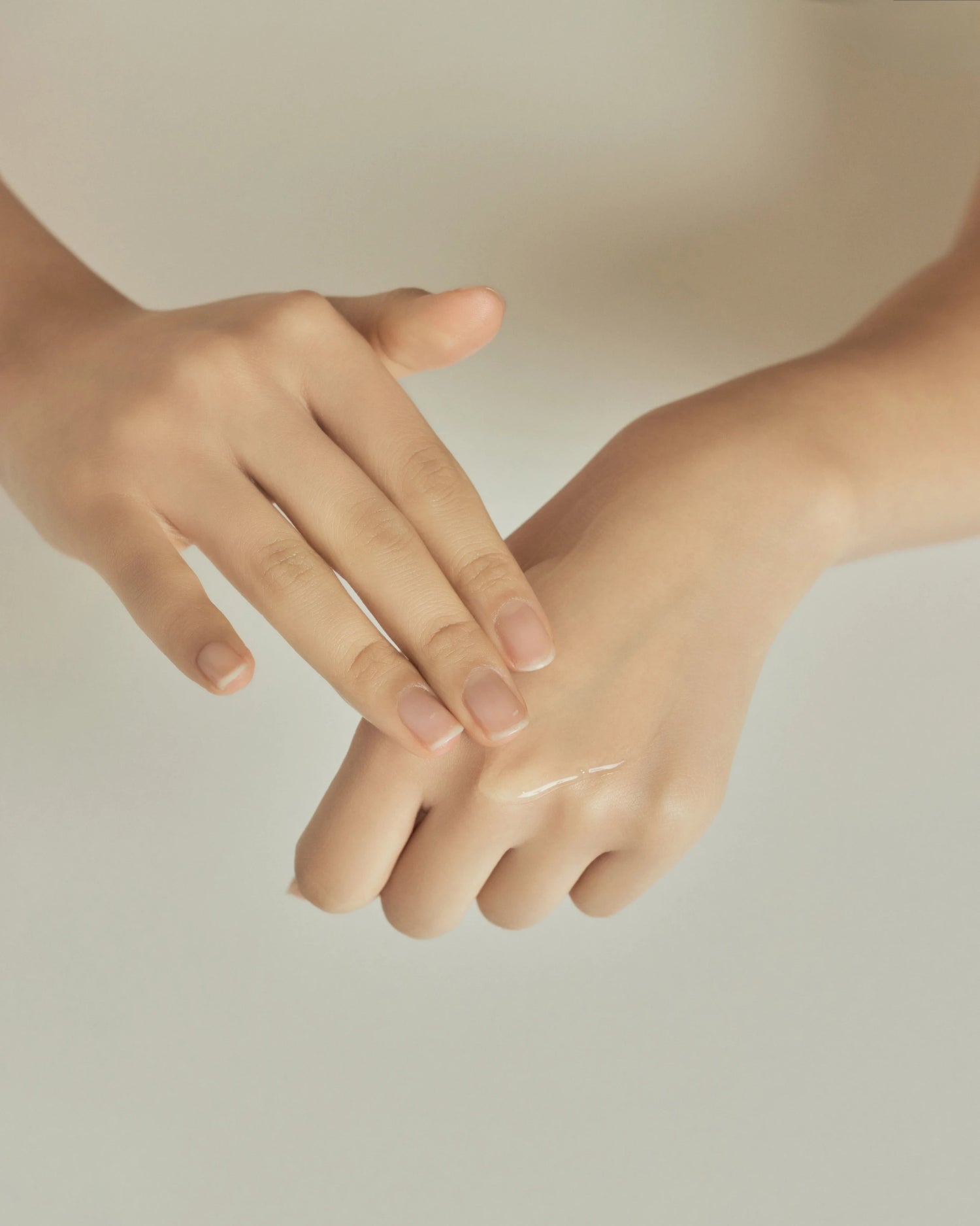 Close-up of two hands applying ACNOLOGY NIACICA (Dr.ACNi) Control Serum to skin